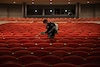 Martin Cruz disinfects seats at an arts center in Odessa, Tex., before its reopening in mid-September.
