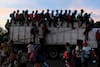 Some of the thousands of migrants traveling in a caravan toward the U.S. border ride atop trucks along a highway in Santiago Niltepec, Mexico, on their way to Juchitan, Mexico, on Oct. 30, 2018. 