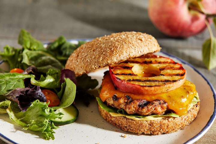 Top chicken burgers with cheddar and apple for sweet, tangy flavors