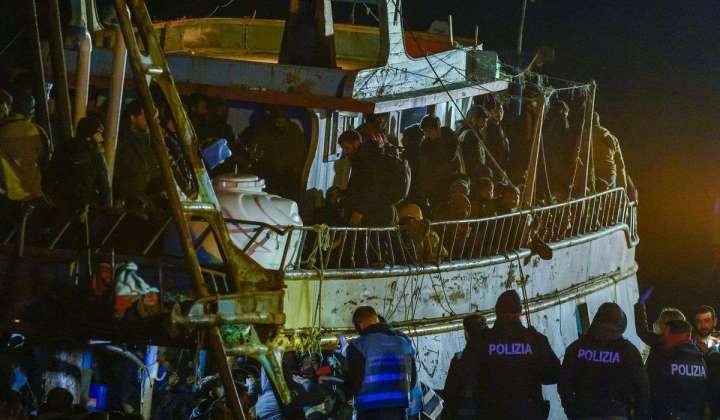 Italy’s coast guard, navy, bring hundreds of migrants ashore